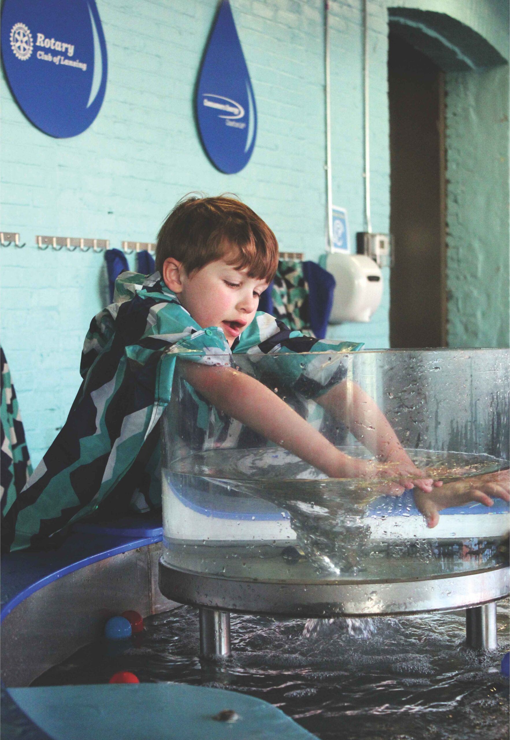 A child explores a water exhibit at Impression 5 Science Center in Lansing, enjoying hands on indoor fun during spring break