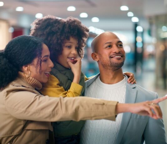 Family shopping together at mom 2 mom sale clarkston browsing kids clothing toys and baby gear at organized consignment event