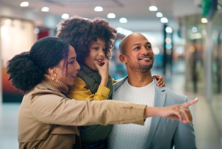 Family shopping together at mom 2 mom sale clarkston browsing kids clothing toys and baby gear at organized consignment event
