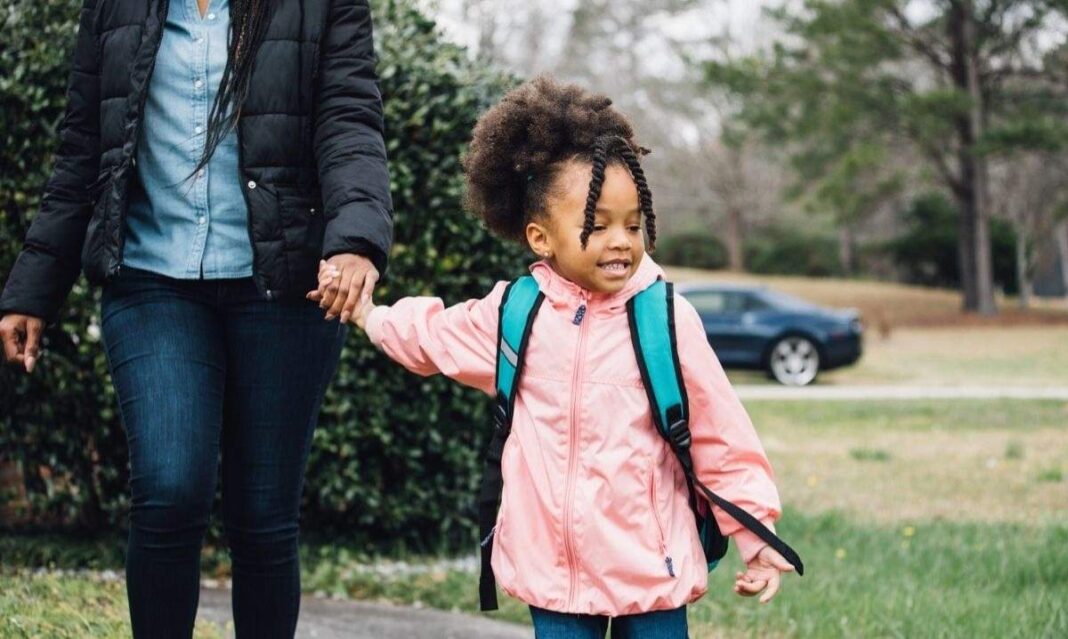 Mother walking preschool child with autism to school helping with morning routine and getting ready