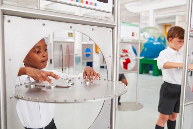 Kids explore interactive sound displays during Sonic Sensation at Ann Arbor Hands-On Museum hands on STEM exhibit about sound waves and hearing