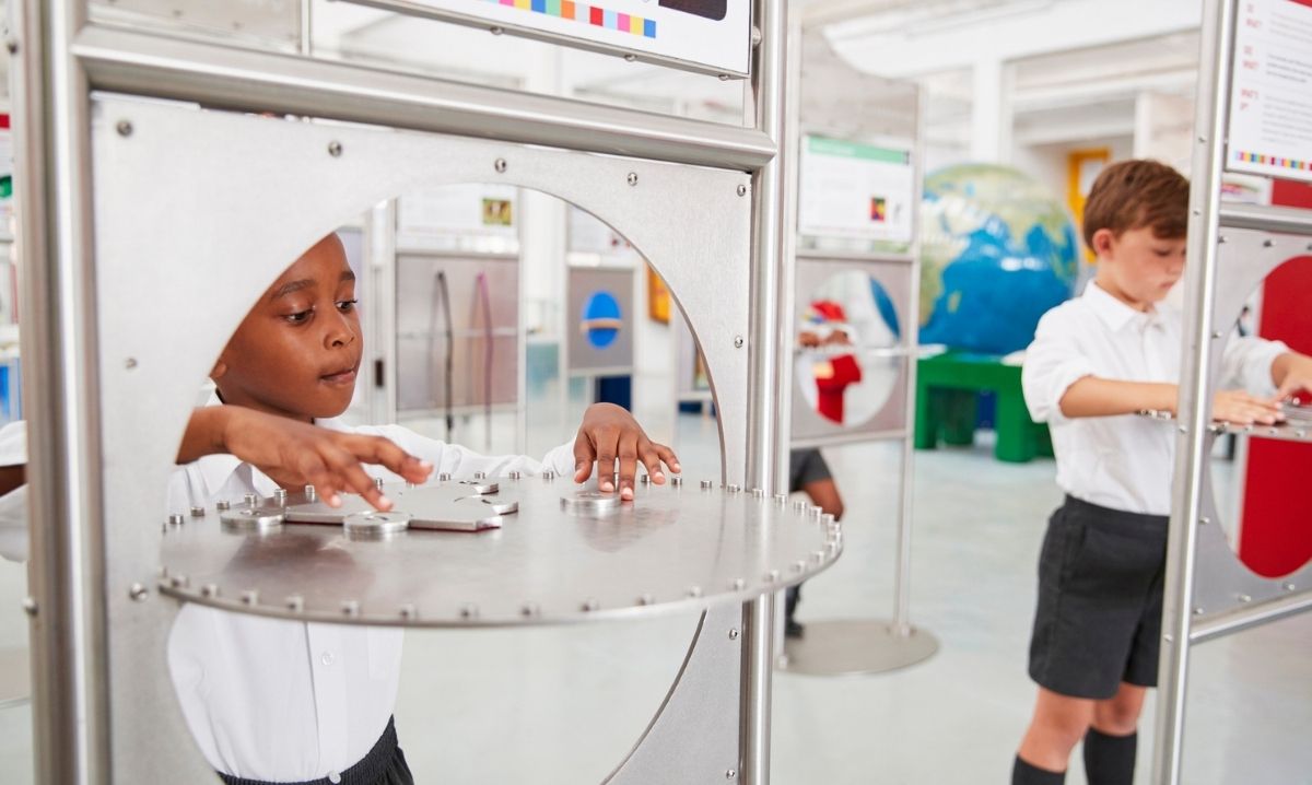 Kids explore interactive sound displays during Sonic Sensation at Ann Arbor Hands-On Museum hands on STEM exhibit about sound waves and hearing