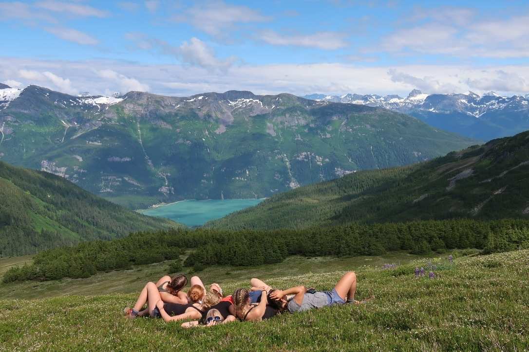 Girls from YMCA Camp Arbutus Hayo-Went-Ha relax during a wilderness trip with mountain views building confidence and friendship