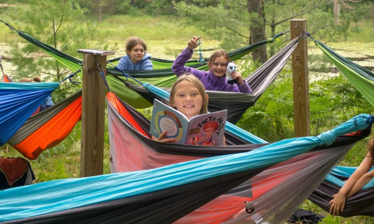 Kids relaxing in hammocks at YMCA Camp Timbers in Northern Michigan during overnight summer camp surrounded by forest and nature