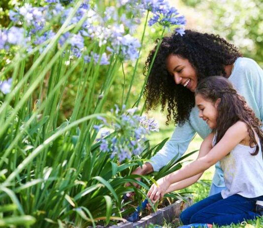 Mother and child gardening together at Bond and Bloom event with flowers and plants at Wint Nature Center enjoying nature activities
