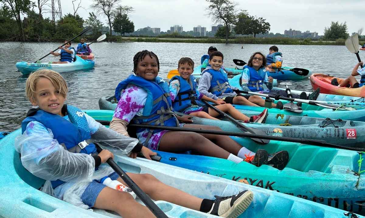 Kids kayaking on the Detroit Riverfront at Camp Explore, a DNR outdoor adventure day and overnight camp in Detroit