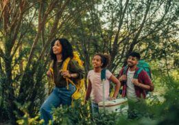 Family hiking on a wooded trail during a trails expo event with parents and kids exploring nature and outdoor activities together