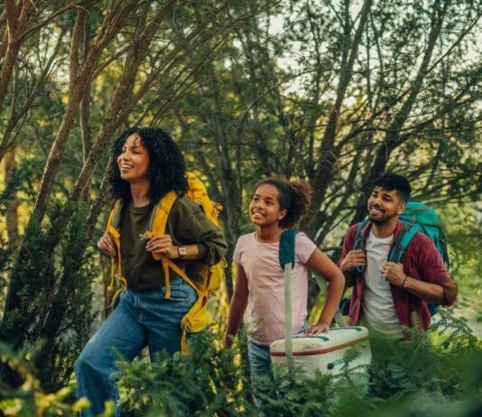 Family hiking on a wooded trail during a trails expo event with parents and kids exploring nature and outdoor activities together