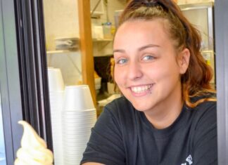 10 family-friendly restaurants in Muskegon Smiling server at an ice cream stand in Muskegon serving sweet treats, highlighting family friendly restaurants and dessert spots