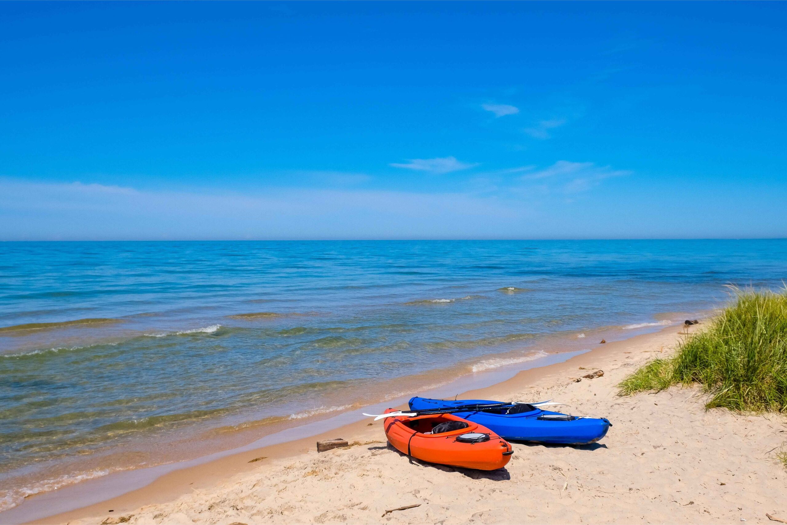 Kayaks on Lake Michigan beach in Muskegon, a relaxing spring activity for families enjoying lakeside views and outdoor adventure