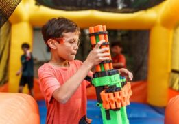 Nerf wars saline recreation center kids blaster battle fun with child aiming toy blaster during active team game in indoor play space