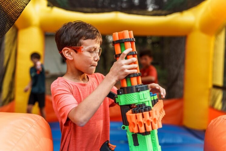 Nerf wars saline recreation center kids blaster battle fun with child aiming toy blaster during active team game in indoor play space