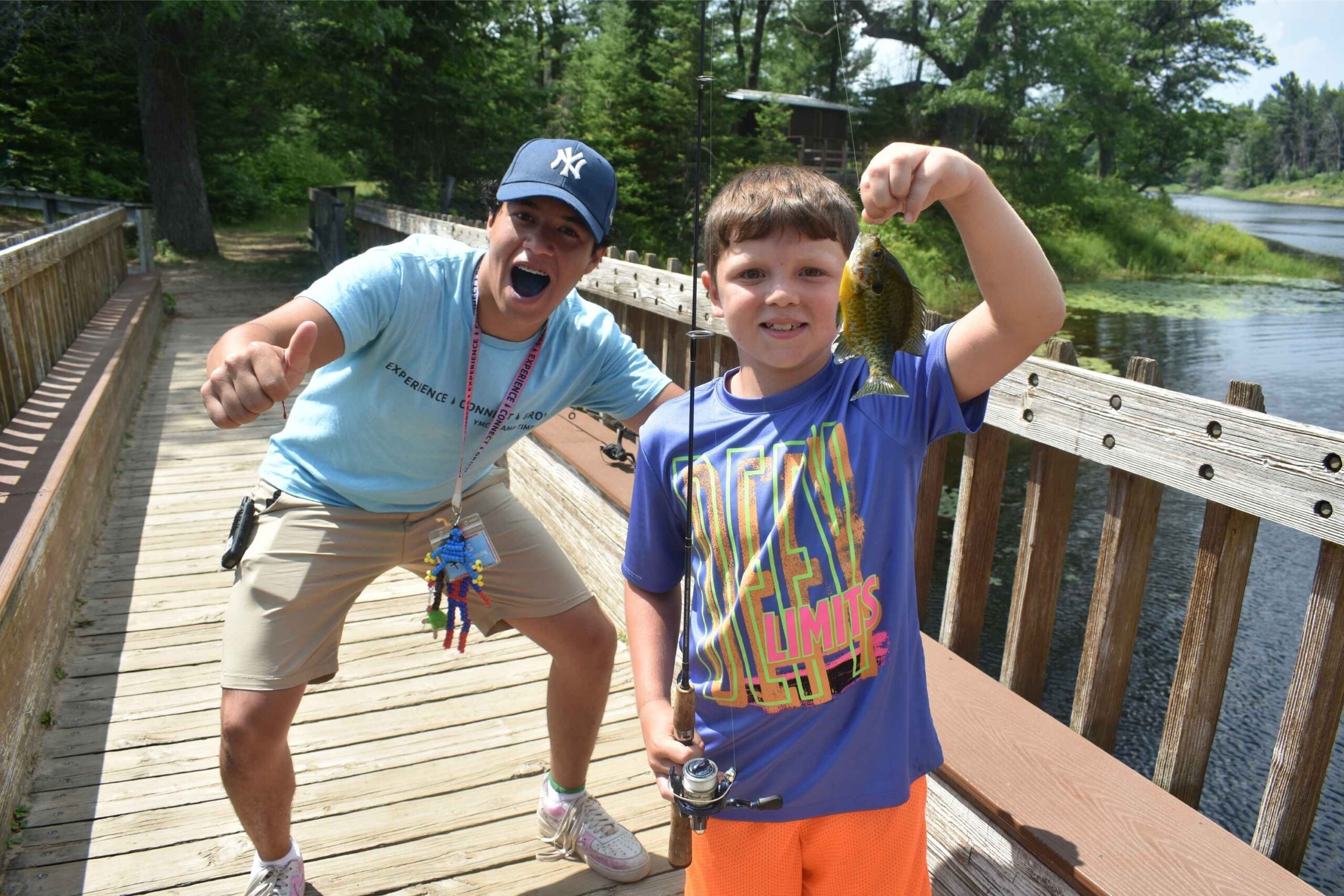A counselor poses with two young campers at YMCA Camp Timbers overnight camp in West Branch, Michigan